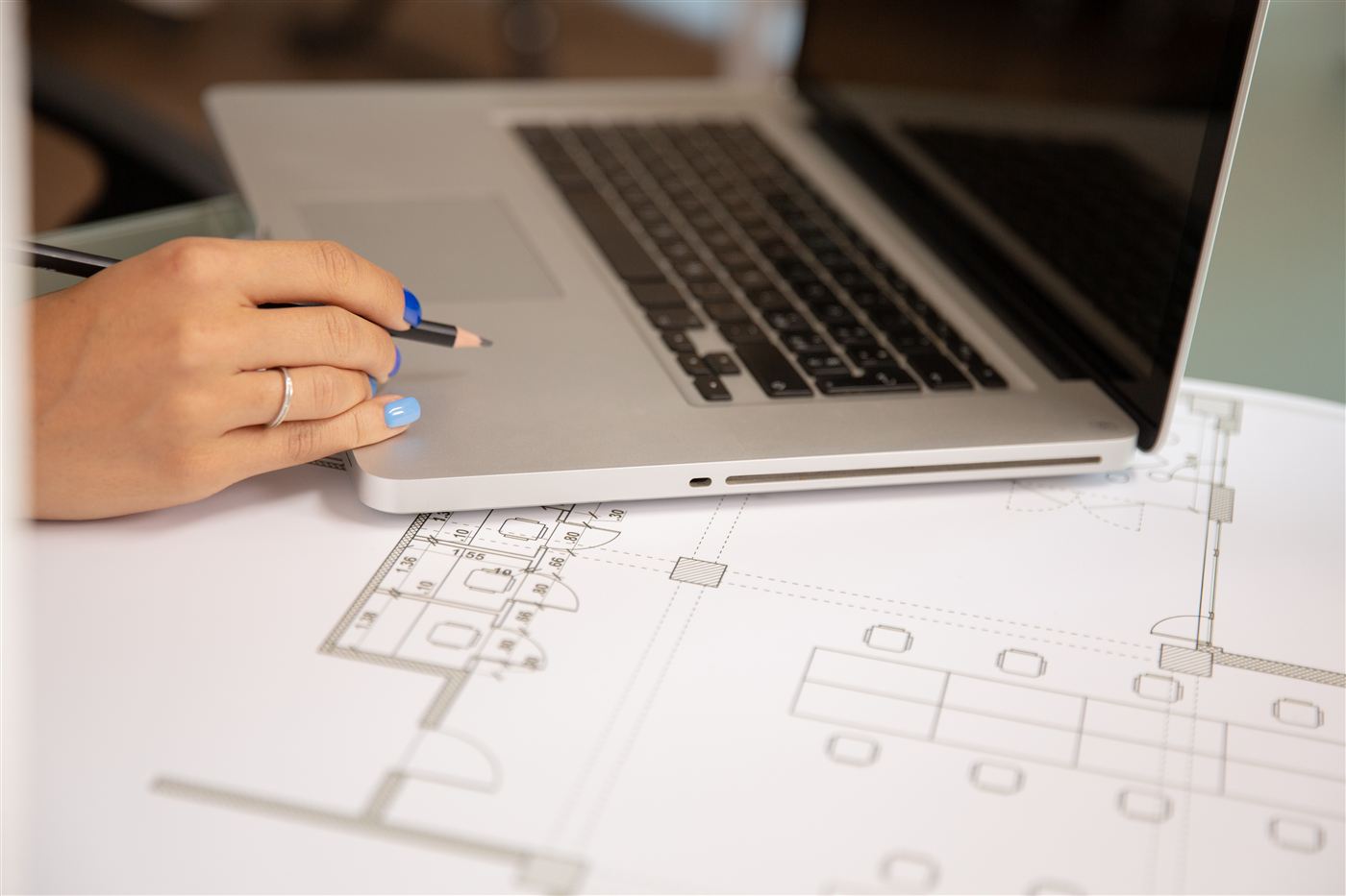 Laptop over blueprints on desk